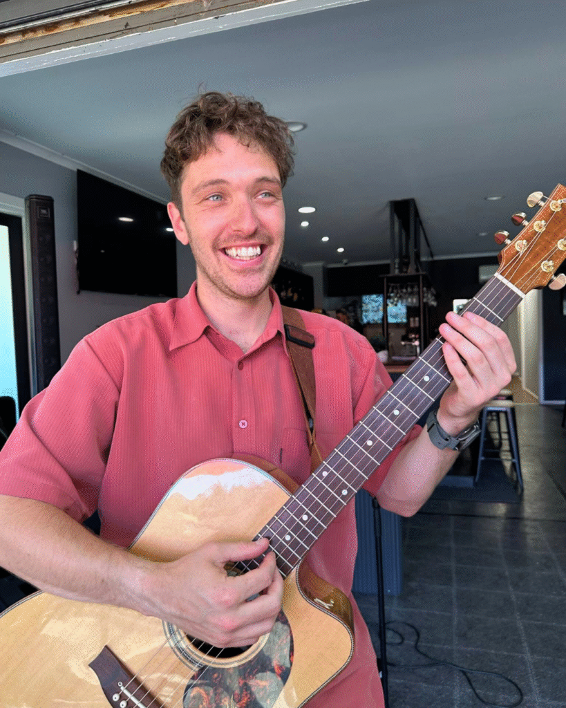 Mitch Matheson smiling with a guitar at The Courthouse Hotel Smythesdale